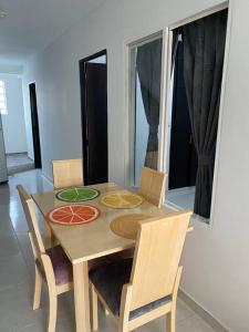 a dining room table with chairs and a painting on it at Apartamento familiar Obdulio in Villavicencio