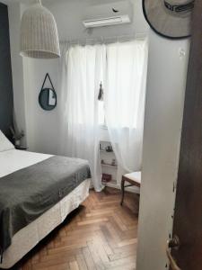 a bedroom with a bed and a window with white curtains at Las Cañitas in Buenos Aires