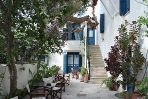 un bâtiment avec des portes bleues, des tables et des chaises dans l'établissement Villa Kynthia, à Panormos Rethymno