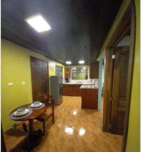 sala de estar con mesa y cocina en Hospedaje Rosa Del Mar, en Isla Grande del Maíz