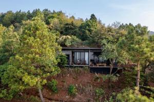 a house on top of a hill with trees at One of a kind countryside home in Tamanique