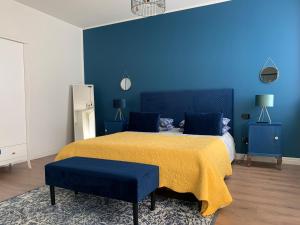 a blue bedroom with a bed with a yellow blanket and blue walls at Al Viale 2 in Negrar