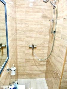 y baño con ducha y puerta de cristal. en Apartment Zhyzhky 9, en Leópolis