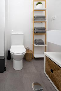 a bathroom with a toilet and a shelf with towels at Douro Afurada Boutique Apartments in Vila Nova de Gaia +51 photos