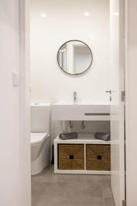 Baño blanco con lavabo y espejo en Douro Afurada Boutique Apartments, en Vila Nova de Gaia