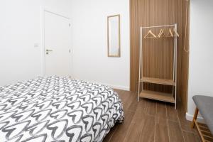 a bedroom with a black and white bed and a cabinet at Douro Afurada Boutique Apartments in Vila Nova de Gaia