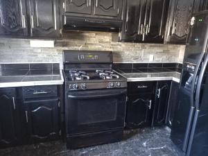 a kitchen with a black stove and black cabinets at Lovely Place in Kingston