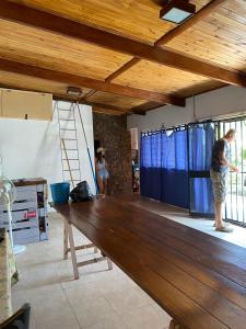 dos personas de pie en una habitación con un banco de madera en Quinta en Villa Constitución