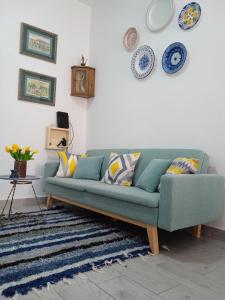 a living room with a green couch and plates on the wall at Apartamentos Lax in Almería