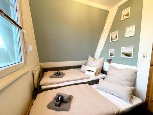 Cette chambre comprend 2 lits et une fenêtre. dans l'établissement Familienfreundliches Ferienhaus in 5 min zum Strand mit Terrasse und kostenlosem Parkplatz, à Cuxhaven