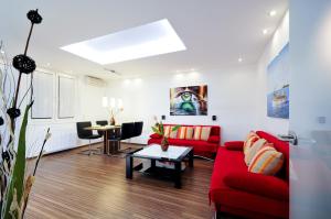 salon z czerwoną kanapą i stołem w obiekcie Apartment Giuliano Vienna w Wiedniu