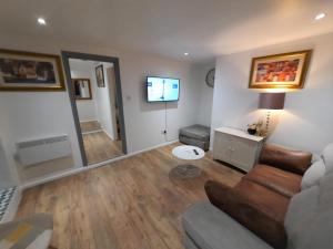 a living room with a couch and a television at 3 Bedroom Semi Detached House with parking, WiFi in Colchester