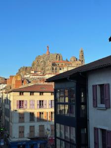a view of a city with a mountain in the background at Maison Pignol in Le Puy en Velay