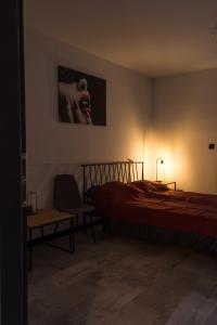 a bedroom with a bed and a chair and a picture at Apartament Black Loft in Nysa