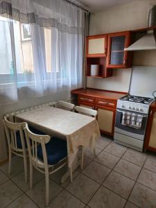 kuchnia ze stołem, krzesłami i kuchenką w obiekcie Przytulne mieszkanie/Cosy flat Chorzów w mieście Chorzów