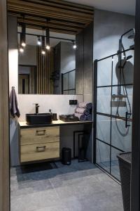 a bathroom with a sink and a mirror at Apartament Black Loft in Nysa