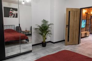a bedroom with a door and a potted plant at Apartament Black Loft in Nysa
