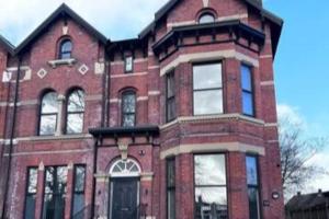a large red brick building with a window at Lovely 2-BR Flat near Salford Royal in Manchester