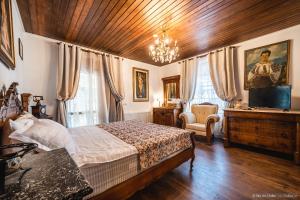 1 dormitorio con 1 cama y TV en una habitación en Rita Art Chalet Voronet en Voroneţ