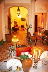 a room with a table with candles and tables and chairs at Riad Chakir Mogador in Essaouira +49 photos