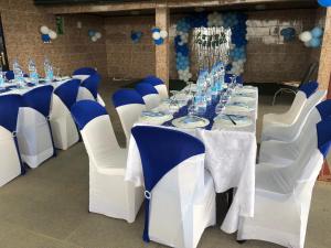 a set of tables and chairs with blue and white table settings at Home Away From Home in Yaoundé