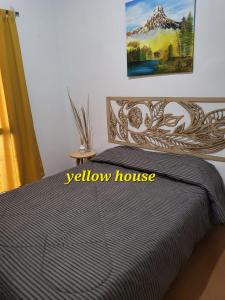 Un dormitorio con una cama con un cartel de casa amarilla. en Yellow House en San Rafael