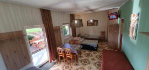 una sala de estar con mesa y sillas y una habitación con ventana en Kwatera u Heni, 