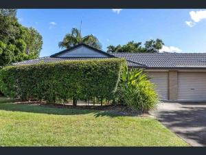 a house with a large bush in front of it at Beach Side Villa Walk to Shops-Pub-Beach in Byron Bay