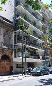 un edificio de apartamentos con coches estacionados frente a él en Departamento Congreso en Buenos Aires