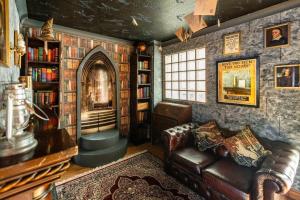 un soggiorno con divano e libreria di Hogwarts Hideaway Themed Property a Garston