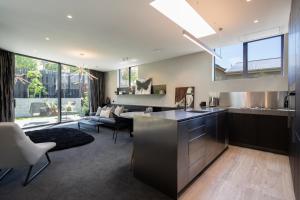 a kitchen and living room with a large window at The Ivy Box Apartment in Queenstown