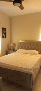 Schlafzimmer mit einem großen Bett und einer Decke in der Unterkunft Turnbull's Apart Hotel in Consuelo