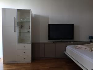 um quarto com uma televisão de ecrã plano e uma cama em Apartment in München em Munique