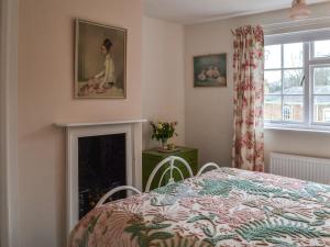 a bedroom with a bed and a fireplace at Coopers Cottage in Louth
