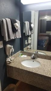 a bathroom with a sink and a mirror at OSU 2 Queen Beds Hotel Room 128 Booking in Stillwater