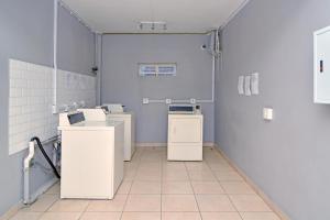 - une salle de bains pourvue d'appareils électroménagers blancs dans l'établissement The Westpoint -Modern ,secure apartment, à Roodepoort
