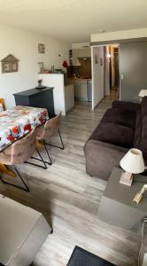 een woonkamer met een bank en een tafel bij Le Cocon Themnest in La Mongie
