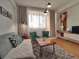 a living room with a couch and two green chairs at Marko's Apartment in Ohrid