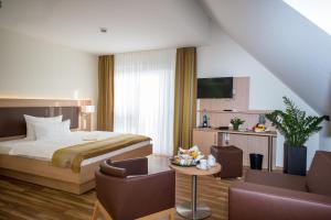 a hotel room with a bed and a table and chairs at Hotel & Restaurant Goldener Pflug in Ludwigsburg