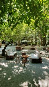 ドゥルカルにあるAlojamiento Rural Molino Del Puenteの木の下のベンチとテーブルのある公園