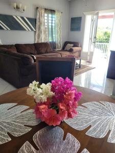 eine Vase mit Blumen auf einem Tisch im Wohnzimmer in der Unterkunft Mount Joy Getaway in Parham