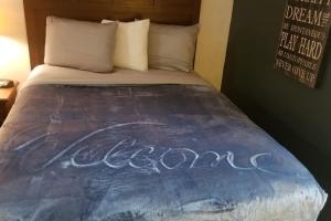 a bed with the word cocacola written on it at Hotel King Bed Hotel Room 120 Booking in Stillwater