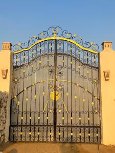 a large black gate with yellow flowers on it at Sahure Pyramid View lnn in Cairo