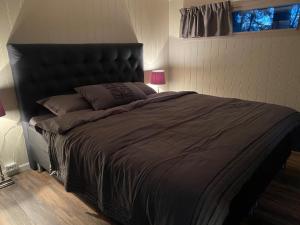 a bedroom with a large black bed with a window at Northern Light cottage 1 