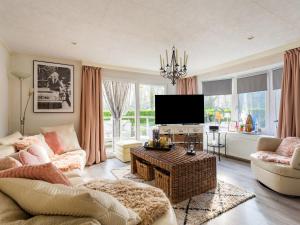 a living room with a couch and a tv at Lovely chalet in Hoek with terrace in Hoek