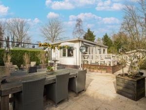 un patio trasero con una mesa y sillas y una casa en Lovely chalet in Hoek with terrace, en Hoek