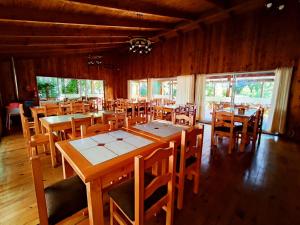 een eetkamer met houten tafels en stoelen bij La Casona Caburgua in Pucón