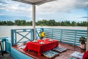 una mesa en la parte trasera de un barco en el agua en DON DET Souksan Sunset Guesthouse and The Xisland Riverview Studio, en Ban Donsôm Tai