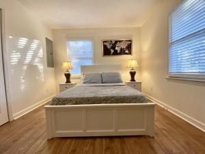 um quarto com uma cama branca e 2 candeeiros em Cozy three bedroom house with fireplace em Wilmington