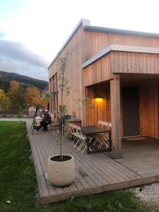 a house with a potted tree on a wooden deck at Delikat hytte omgitt av Hallingdals vakre fjell in Ål